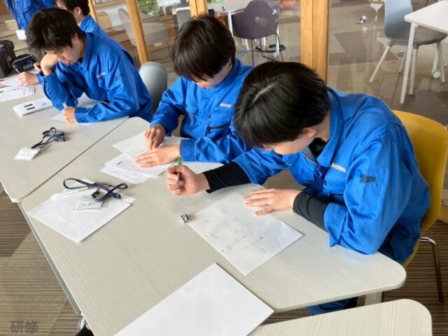 新入社員の社内研修を実施しました🌱

こんにちは！AtomsWorldの佐野です。

 先日、グループ会社の山口電気工事へ入社した新入社員たちが、1ヶ月の現場研修の振り返りを行うため、久しぶりに社内で研修を行いました！

まずは座学にて、これまでの現場研修の振り返り。 「自分たちにできたこと・できなかったこと」をそれぞれが率直に共有し合いました。

さらに、電気工事士（一種・二種）の資格によって任される業務の違いを改めて学び、将来に向けて「何歳までにどの資格を取得するか」を考える時間も。 

資格の大切さや工具の扱い方を再確認し、これからのキャリアを少しずつイメージする良いきっかけになったようです。

そして後半からは現場の先輩も合流し、直接「ロープ結び」の指導を受ける場面も！ 基礎でありながらとても重要な技術を、みんな集中して教わっていました。✨

いよいよ本格的に配属先の部署での業務がスタートし、プロへの一歩を踏み出す新入社員の皆さん。
これからの成長が本当に楽しみです！

企業情報はプロフィールURLより 👉 atomsworld.co.jp 弊社ZEB社屋の見学をご希望の方は是非コメント欄へご連絡ください！

#AtomsWorld #山口電気工事 #新入社員 #社内研修 #電気工事